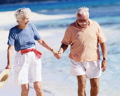 Older couple walking on a sunny beach